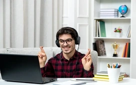 A young man studying online with headphones and a laptop, symbolizing how free online courses can help learners strengthen their CV in 2025.