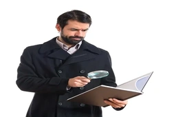A professional examining documents with a magnifying glass, symbolizing the investigative skills essential in high-demand forensic accounting roles.