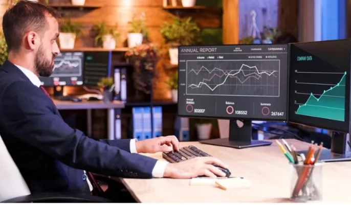 Marketer reviewing AI-driven sales dashboards on dual monitors – how AI boosts customer engagement in 2024