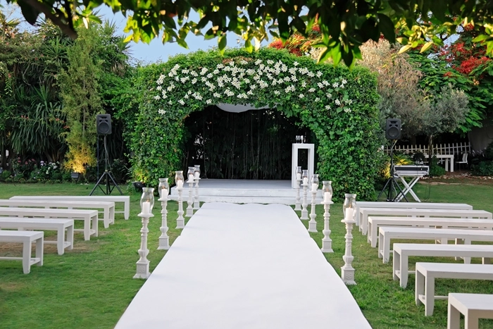 Elegant outdoor wedding ceremony setup with floral arch and aisle seating, representing wedding planner training and event styling.