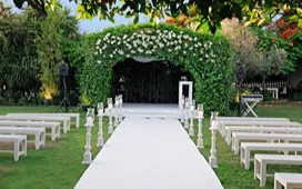 Elegant outdoor wedding ceremony setup with floral arch and aisle seating, representing wedding planner training and event styling.