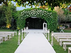 Elegant outdoor wedding ceremony setup with floral arch and aisle seating, representing wedding planner training and event styling.