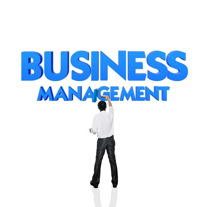 Business professional standing before large “Business Management” text, symbolising leadership, growth, and management studies.