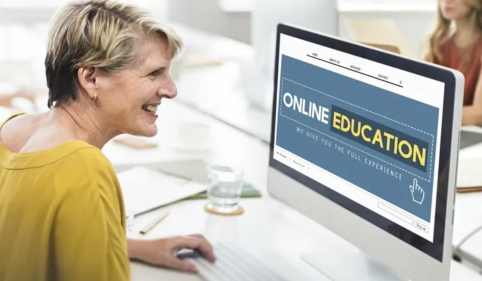 A woman exploring online education options on a desktop computer, representing how learners can choose the right free online course for career growth.