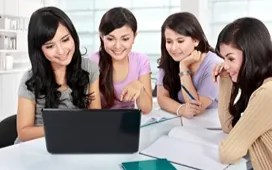 Students reviewing an online course on a laptop together, highlighting tips for choosing the ideal home study course.