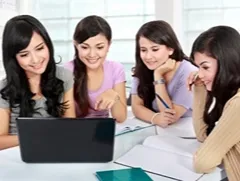 Students reviewing an online course on a laptop together, highlighting tips for choosing the ideal home study course.
