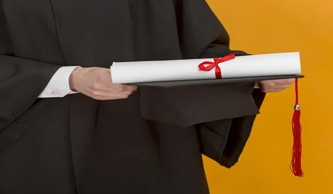 A graduate holding a diploma and mortarboard, symbolizing achievement and the ongoing learning encouraged through Continuing Professional Development (CPD).
