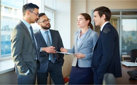Business professionals discussing documents in an office – corporate communication skills for workplace success.