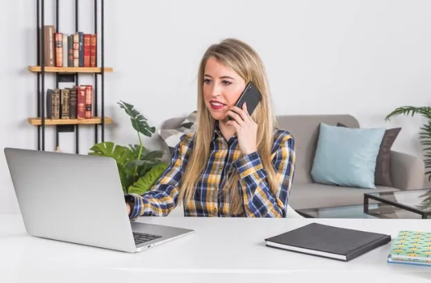 Woman taking a customer service call while working on laptop at home – exploring work-from-home service careers.