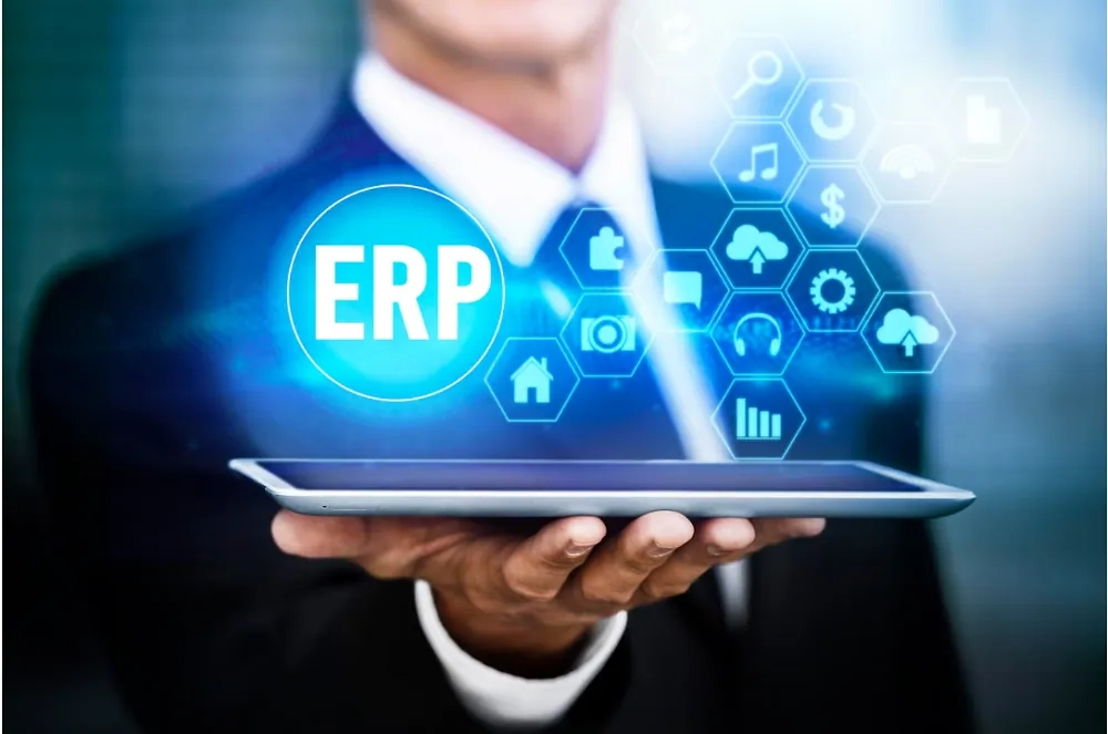 Business professional holding a digital tablet displaying an ERP interface, representing enterprise resource planning systems and modern business management.