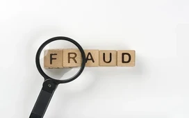 A magnifying glass highlighting the word fraud, symbolizing investigation and analysis in financial fraud detection and forensic accounting.
