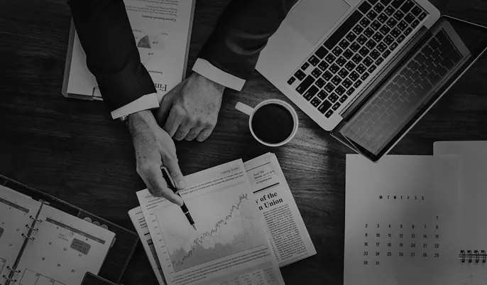 A professional reviewing financial reports and data charts on a desk, symbolizing analytical work involved in modern forensic accounting careers.