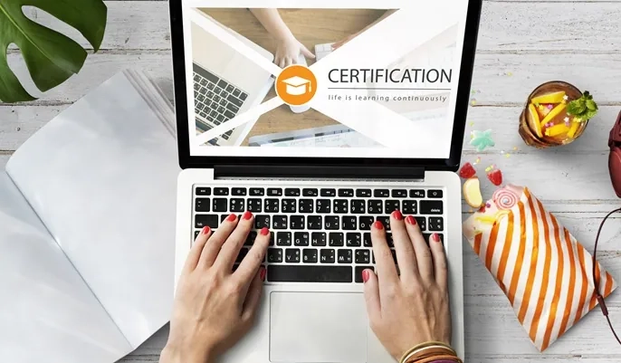 A person typing on a laptop displaying an online certification screen, representing how learners can earn free certificates from OHSC.