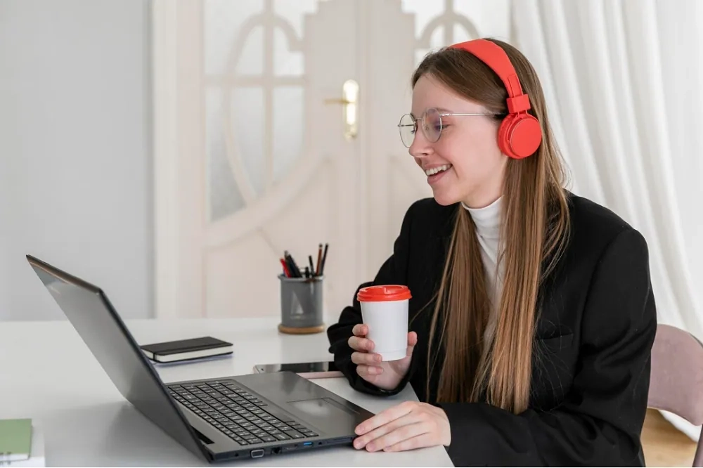 Woman learning online with headphones and laptop – free online courses for professional development and career success.