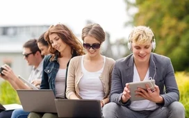 Group of young learners studying online with laptops and tablets, representing free online courses with certificates updated for 2026.