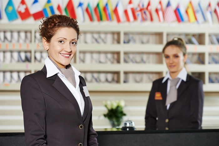 Two hospitality professionals at a hotel reception desk, representing ways to boost skills and career prospects in the hospitality industry.