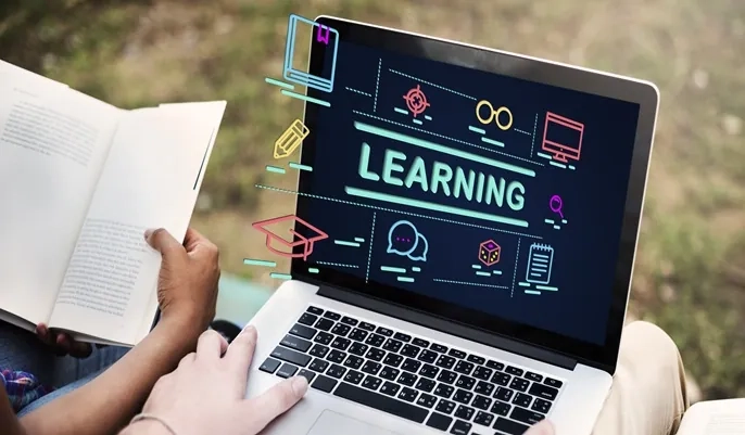 A learner using a laptop with digital learning icons displayed, representing the flexibility and benefits of studying at your own pace with OHSC.