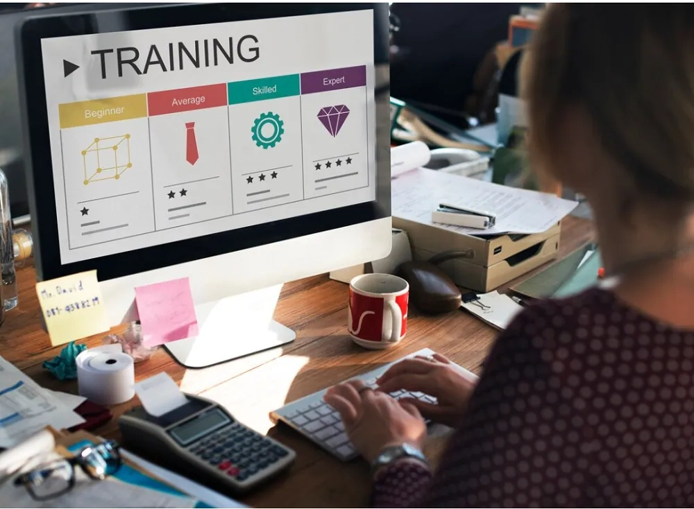 Person using a computer displaying an online training dashboard, symbolizing modern learning management solutions and digital education systems.