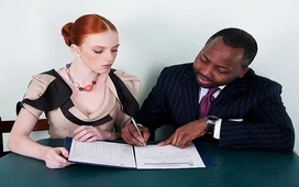 Life coach guiding a client through paperwork in a one-to-one session, representing mentoring skills and life coaching success.