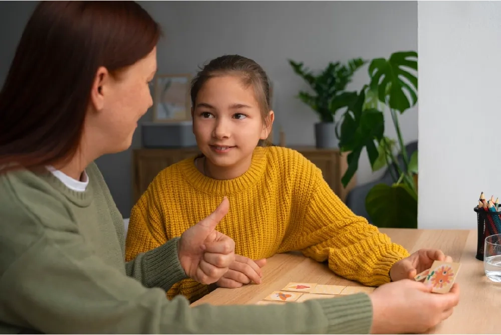 Child speaking with an adult during a supportive discussion, representing guidance and behavioural support for oppositional behaviour disorder.