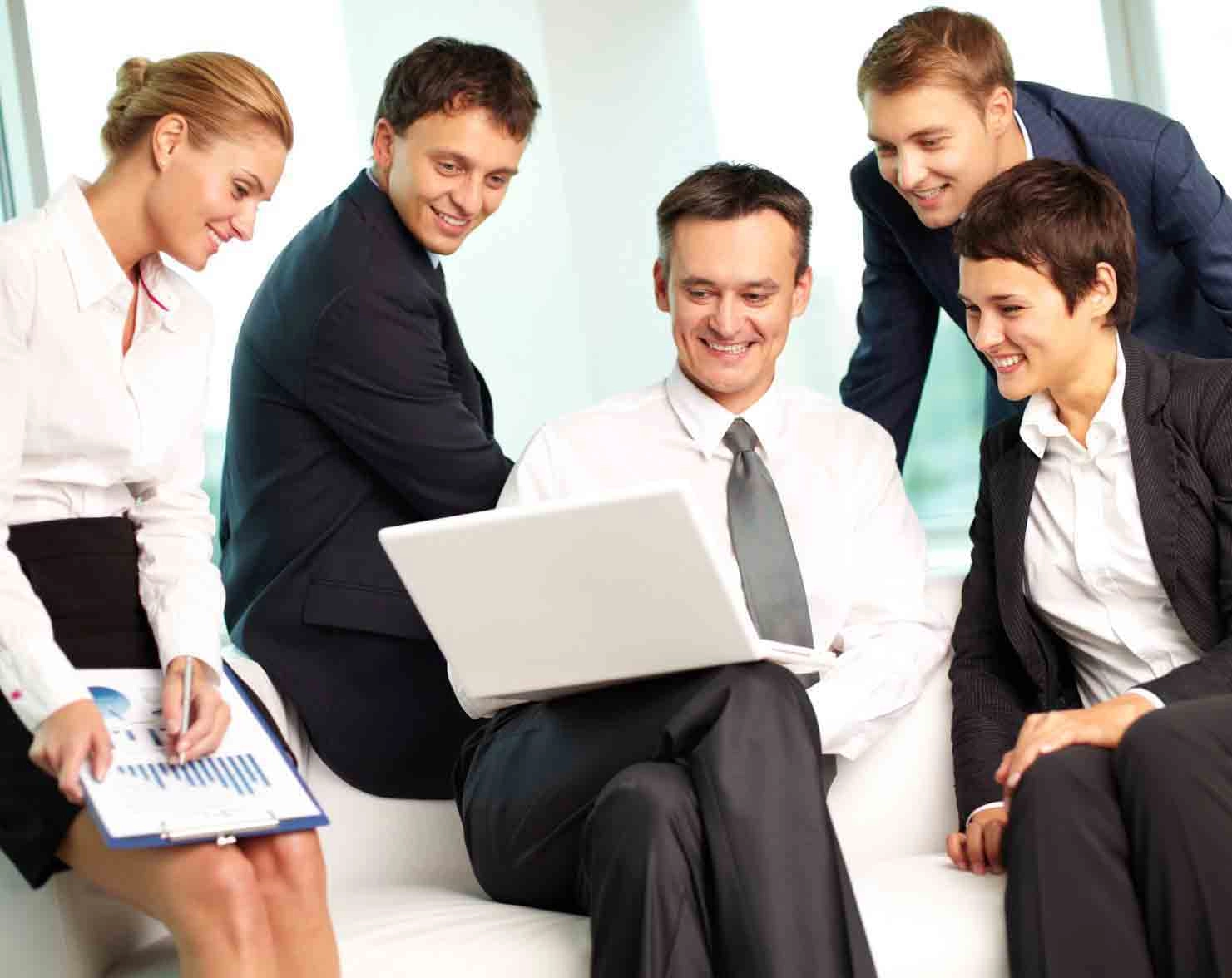 Business team smiling and discussing ideas around a laptop, representing collaboration, innovation, and motivation to start a business.