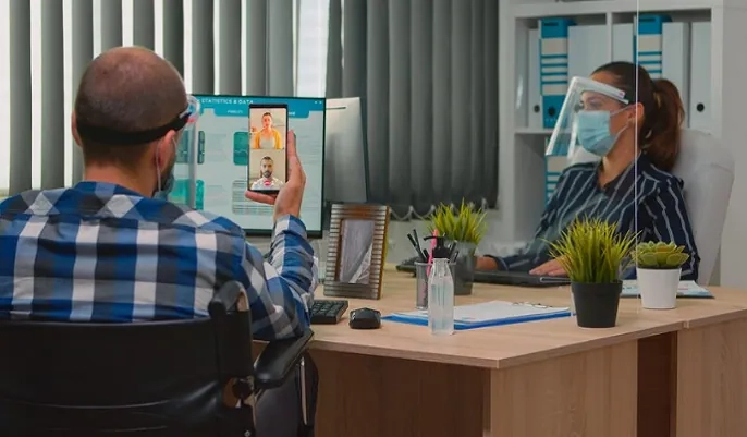 Two professionals communicating through a video call in an office, illustrating virtual teamwork and how to find remote project management job opportunities.