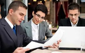 Project managers reviewing documents in a meeting, illustrating common rookie errors and lessons in project management.