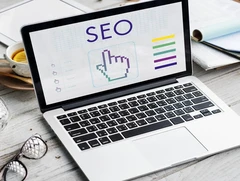 Laptop displaying SEO graphics and analytics, illustrating strategies for improving search engine positioning and boosting website visibility.