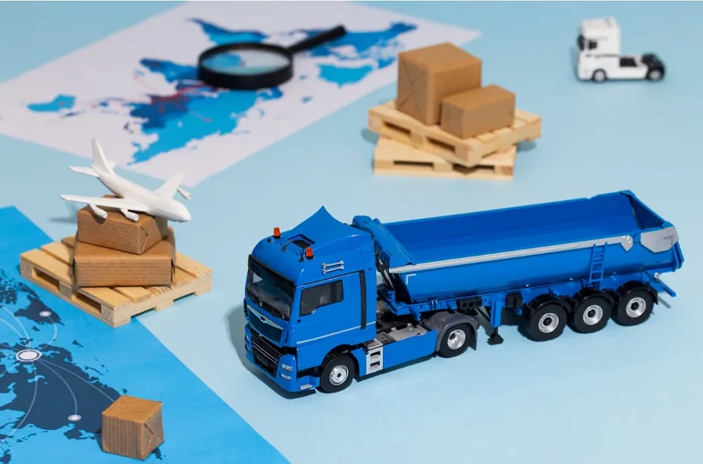 Model truck, cargo boxes and map illustrate supply chain logistics – learn SCM basics with OHSC online courses.