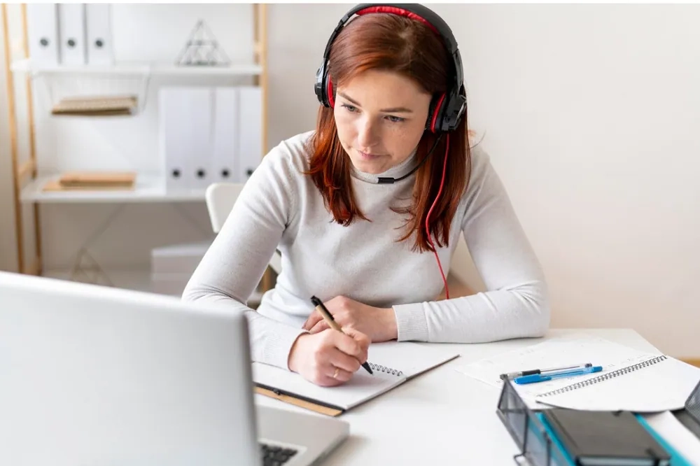 Student taking notes during online lesson at home – discover top free OHSC courses and certificates.