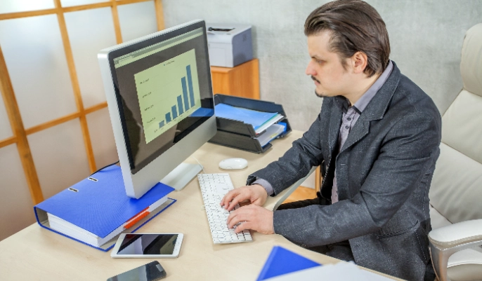 Financial analyst reviewing data charts on computer for accounting for forensic accounting course training and career growth