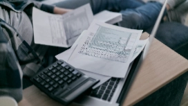 Calculator, laptop and financial worksheets on desk – learn accounting concepts and standards in OHSC short course