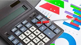 Close-up of a calculator, pen, and financial charts illustrating advanced analysis for the Diploma in Accounting and Finance QLS Level 7.