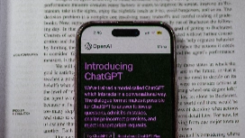 Smartphone displaying ChatGPT beside educational material, illustrating advanced prompt writing and AI learning