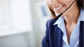 A close-up of a smiling customer service professional wearing a headset, representing advanced communication and service excellence training.
