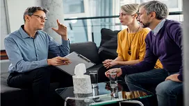 Counsellor speaking with a couple during a therapy session, representing advanced communication and relationship-support skills taught in Level 7 counselling courses.