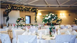 Elegant banquet hall with floral centerpieces, formal table settings and décor, representing the Level 5 Advanced Diploma in Event Management.