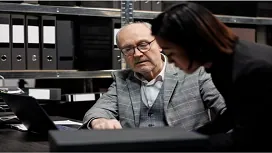 A senior professional guiding a colleague while reviewing financial documents, reflecting advanced forensic accounting skills at QLS Level 7.