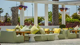 Stylish outdoor seating area with coordinated cushions, modern décor and natural surroundings, representing Level 7 Advanced Diploma in Interior Design.