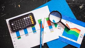 Business charts, calculator and reports illustrating Microsoft Excel data analysis tools for advanced reporting and insights