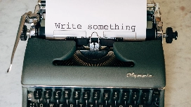 Vintage typewriter displaying “Write something”, symbolising advanced prompt writing techniques and AI prompt engineering skills