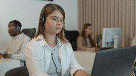 Customer service agent at computer with headset – learn AI-powered customer support skills online with OHSC