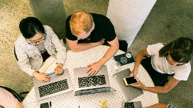 Top-down view of team using laptops and tablets for online sales – learn AI for e-commerce marketing with OHSC