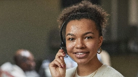 Smiling customer service agent wearing headset – explore AI for sales optimization short course with OHSC