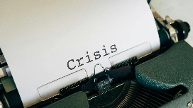 The word “Crisis” typed on a sheet of paper in a typewriter, symbolising risk, emergency scenarios and AI-supported crisis management strategies.