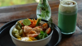 A nutritious meal bowl and green health drink on a wooden table, representing modern nutrition insights and AI-supported dietary planning.