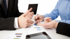 Business professionals reviewing payroll charts and data, representing automation skills taught in OHSC’s free AI in Payroll Processing course.