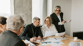 Team of business professionals reviewing charts and documents, illustrating AI-driven innovation in product and service development.