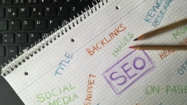 Notebook with SEO notes and pencil beside keyboard, representing AI for SEO-optimised content writing course.