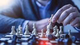 Chess player making a strategic move to demonstrate analytical thinking skills and logical reasoning abilities